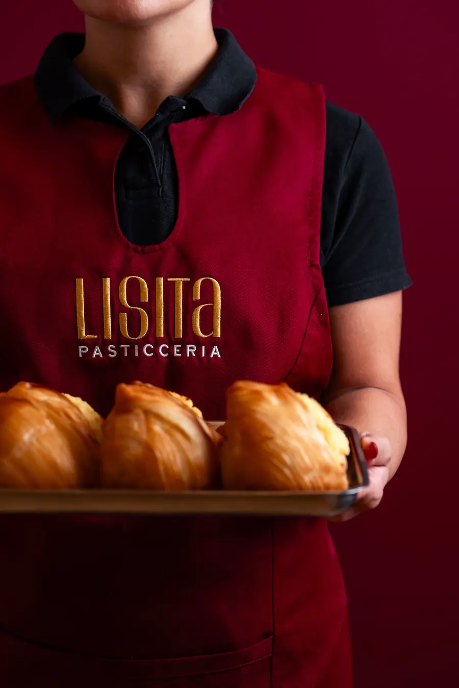 A Lisita pastry chef holding a tray of pastries